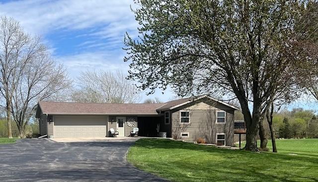 ranch-style house with a garage and a front lawn