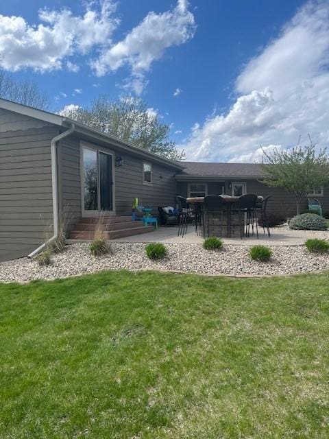 back of house with a patio and a yard