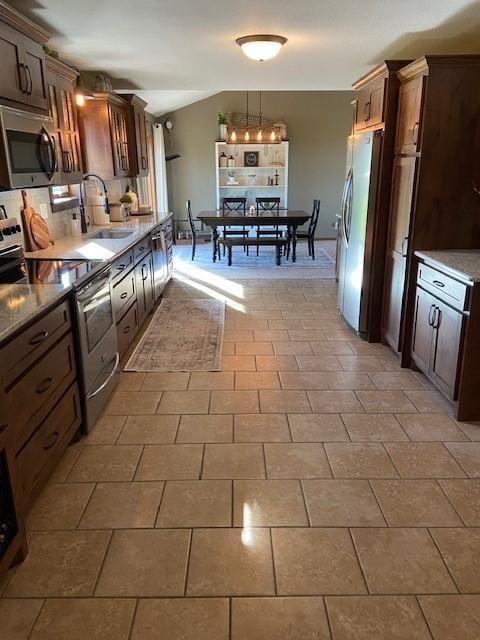 kitchen featuring hanging light fixtures, stainless steel appliances, sink, and tile flooring