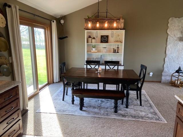 dining space with lofted ceiling, a wealth of natural light, and carpet