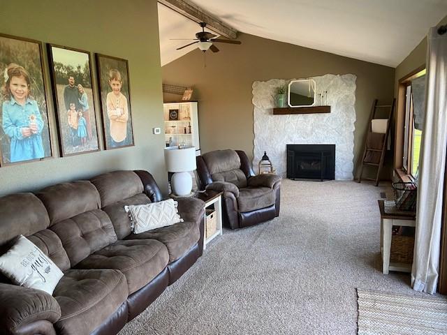 living room featuring carpet, vaulted ceiling with beams, and a fireplace