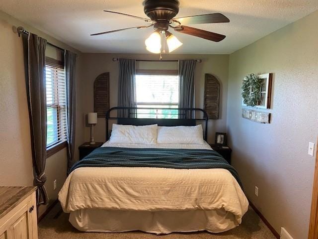 bedroom featuring carpet flooring, ceiling fan, and multiple windows