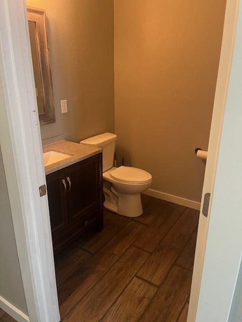 bathroom featuring wood-type flooring, vanity, and toilet