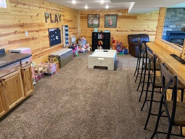 rec room with carpet and wooden walls