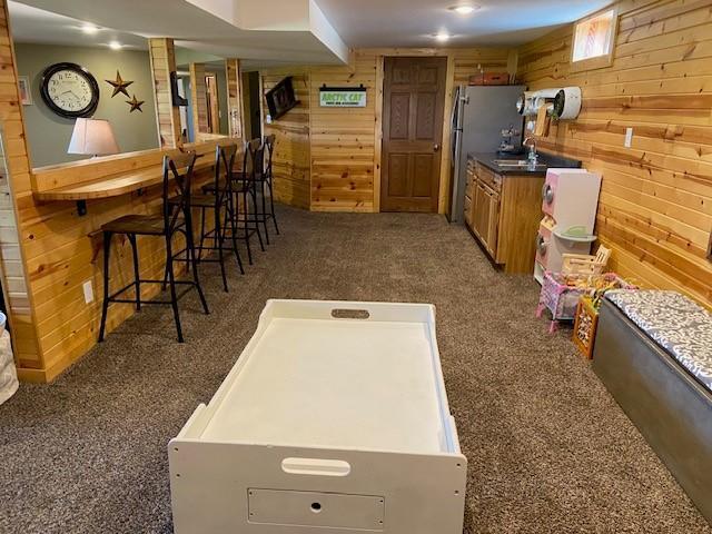 game room with wood walls and dark carpet