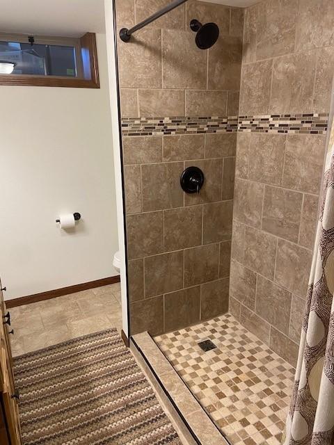 bathroom with tile flooring, toilet, and a shower with shower curtain