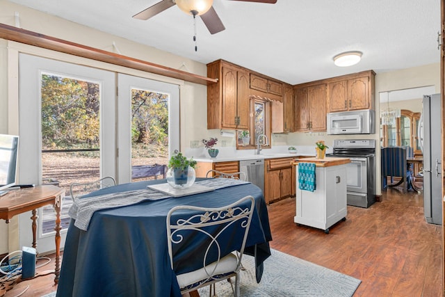 kitchen featuring dark hardwood / wood-style floors, ceiling fan, sink, and appliances with stainless steel finishes