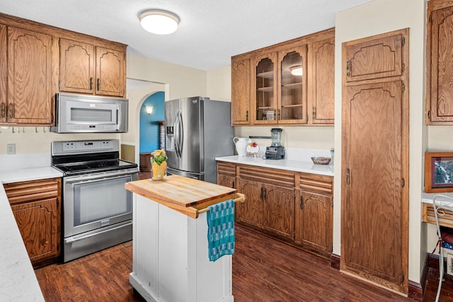 kitchen with dark wood-type flooring, stainless steel appliances, and a textured ceiling