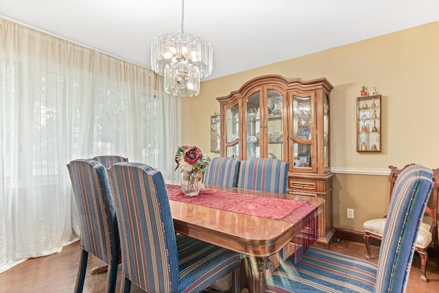 dining space featuring hardwood / wood-style floors and a notable chandelier