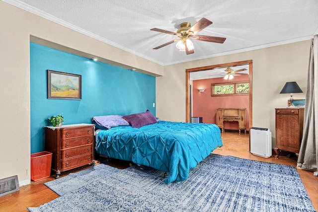 bedroom with ceiling fan, light hardwood / wood-style flooring, a textured ceiling, and ornamental molding