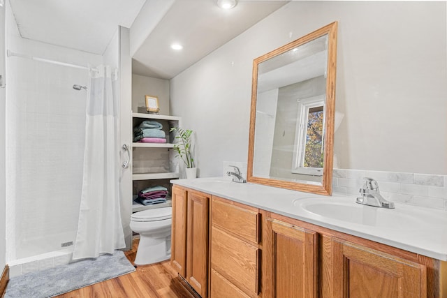 bathroom with hardwood / wood-style floors, vanity, toilet, and walk in shower