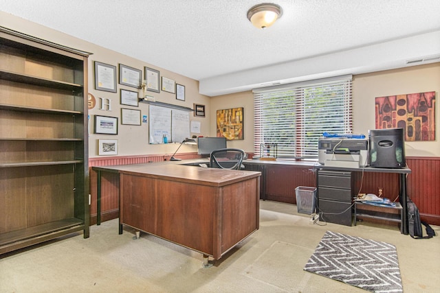 carpeted home office with a textured ceiling