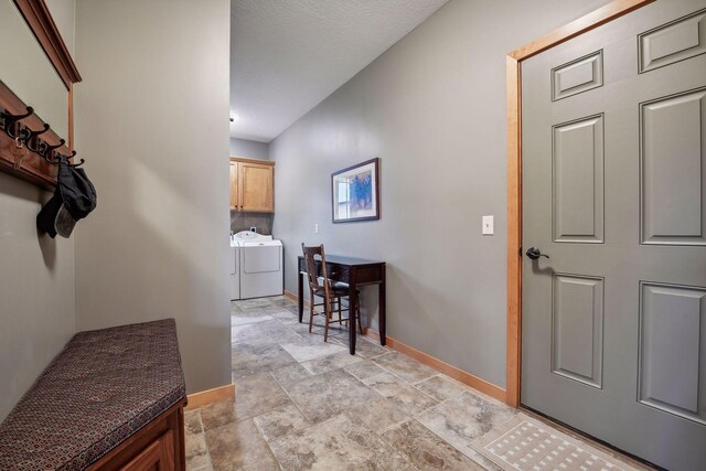 entryway with a textured ceiling and separate washer and dryer