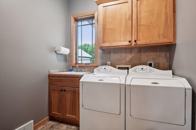 clothes washing area featuring cabinets and washing machine and dryer