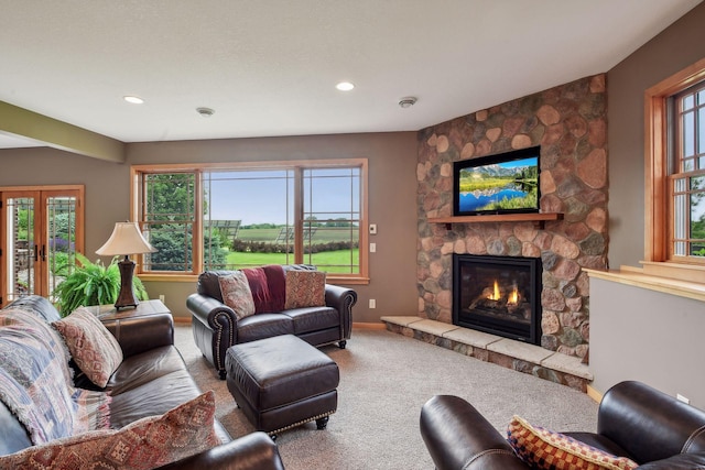 living room featuring carpet and a stone fireplace