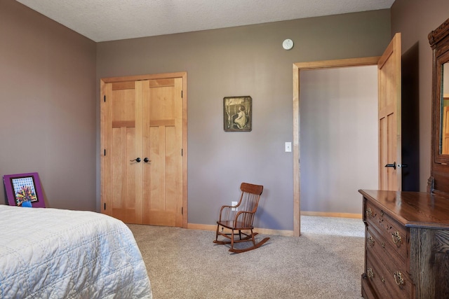 bedroom with light carpet, a textured ceiling, and a closet