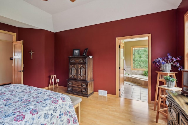 bedroom with light hardwood / wood-style flooring, ensuite bath, and ceiling fan