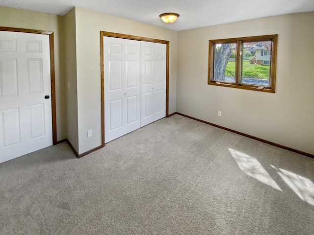 unfurnished bedroom with a closet and light colored carpet