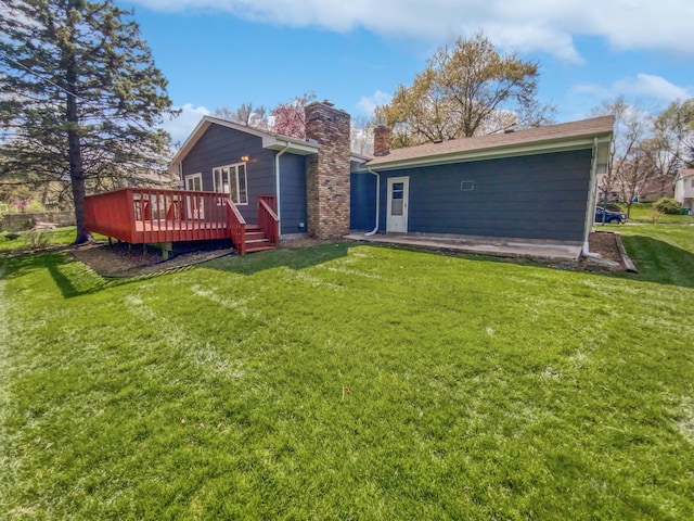 rear view of house with a lawn and a deck