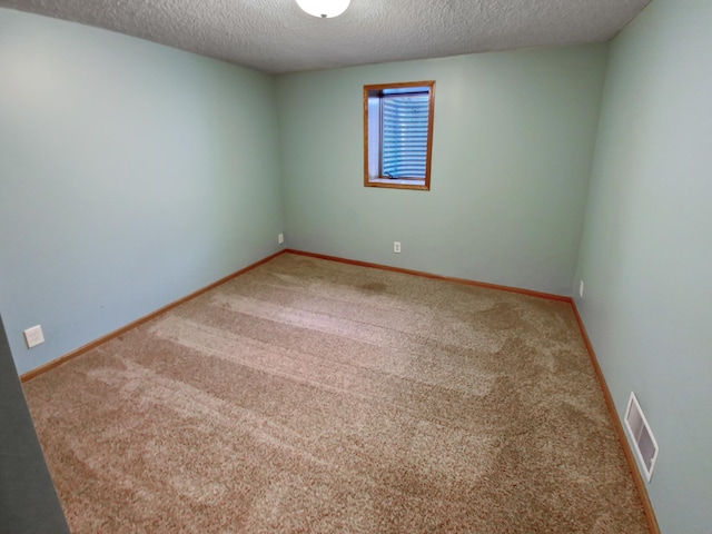 unfurnished room featuring carpet flooring and a textured ceiling