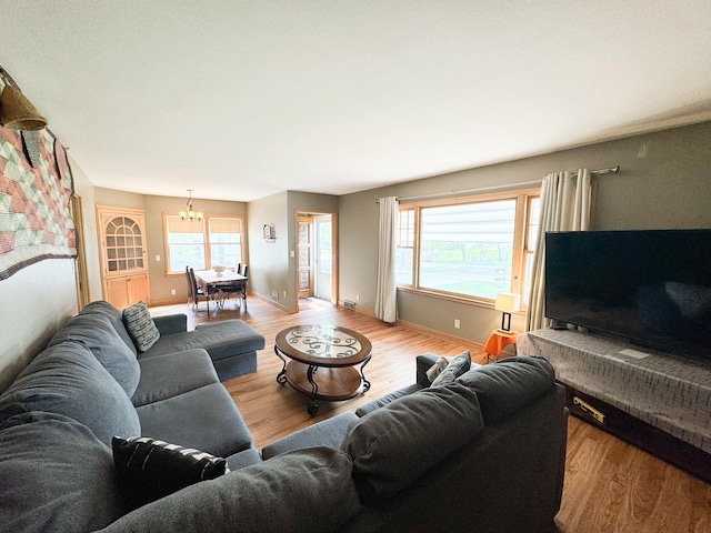 living room with an inviting chandelier and light wood-type flooring