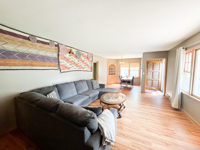 living room with a chandelier and light hardwood / wood-style floors