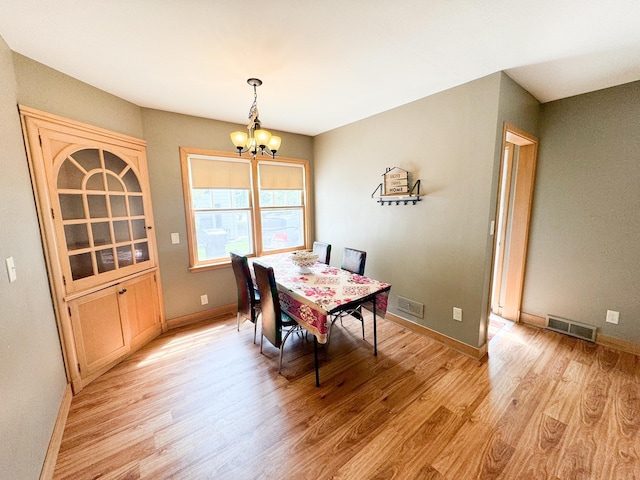 dining room featuring an inviting chandelier and light hardwood / wood-style flooring