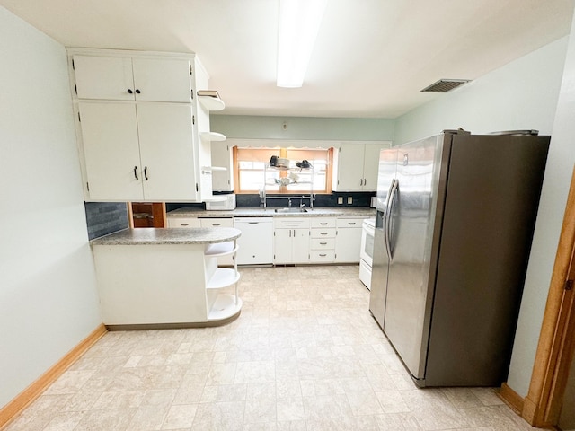 kitchen featuring white cabinetry, tasteful backsplash, range, stainless steel fridge, and white dishwasher