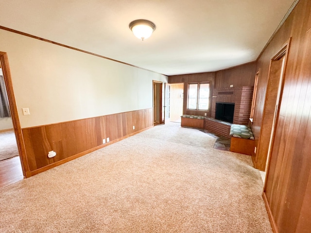 unfurnished living room featuring crown molding, light carpet, and a fireplace