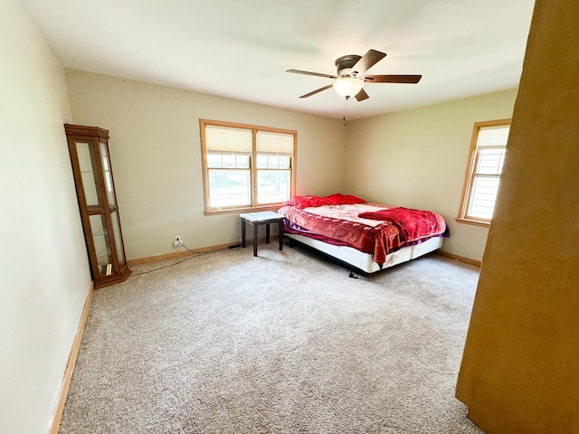 bedroom with multiple windows, ceiling fan, and carpet flooring