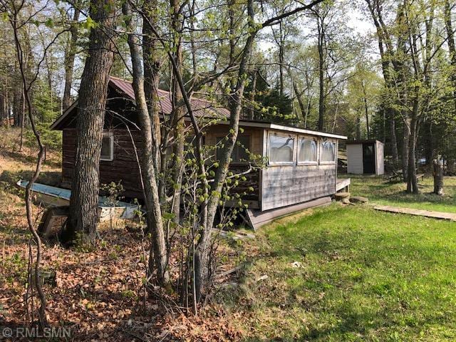 view of property exterior with a lawn and a shed