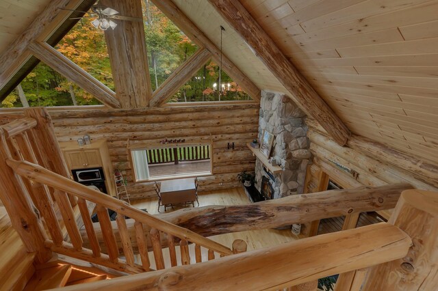 staircase with wood ceiling, plenty of natural light, lofted ceiling with beams, and log walls