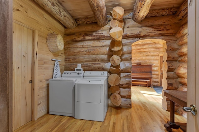 washroom with wood ceiling, washer and dryer, rustic walls, and light wood-type flooring