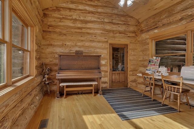 interior space featuring wooden ceiling, log walls, hardwood / wood-style flooring, ceiling fan, and lofted ceiling