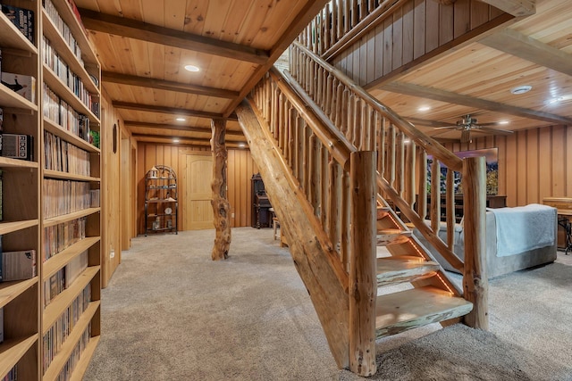 stairs featuring light carpet, wooden ceiling, beamed ceiling, and wooden walls