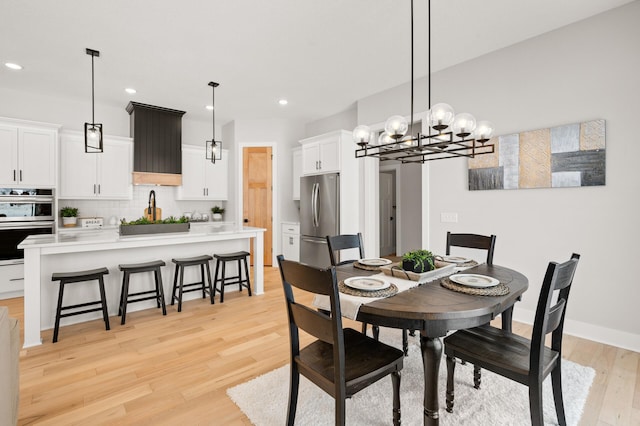 dining room with an inviting chandelier and light hardwood / wood-style flooring