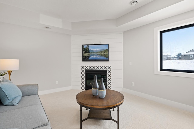 living room with a tray ceiling and carpet flooring