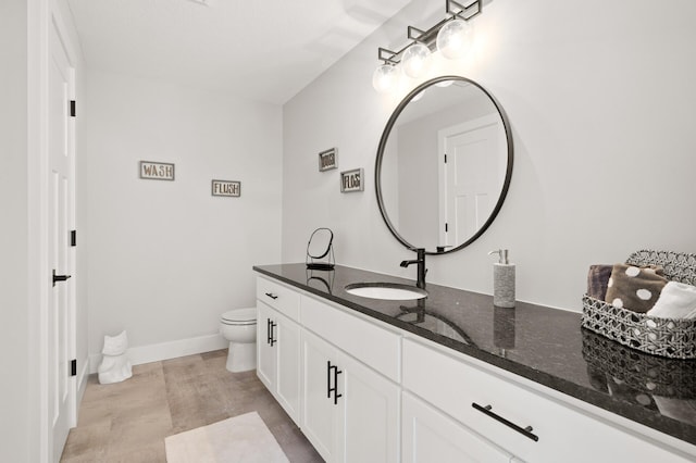 bathroom with tile flooring, vanity, and toilet