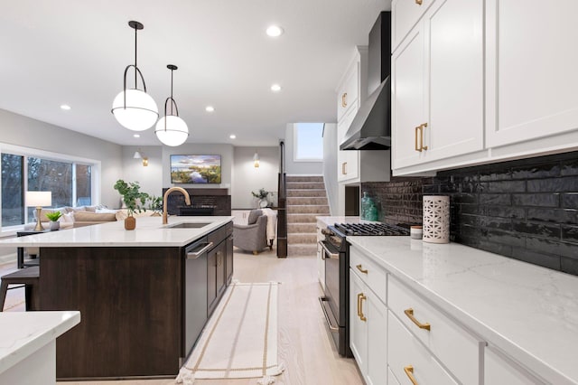 kitchen with decorative light fixtures, light hardwood / wood-style flooring, tasteful backsplash, sink, and gas range oven