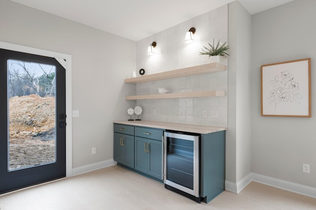 bar featuring beverage cooler and backsplash