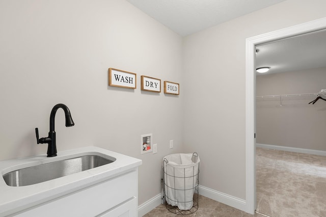 laundry area featuring sink, light carpet, and washer hookup