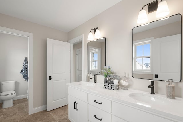 bathroom with a wealth of natural light, toilet, tile flooring, and dual vanity