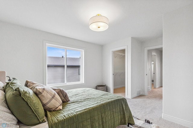 carpeted bedroom featuring a spacious closet and a closet