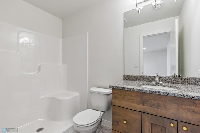 bathroom featuring vanity, toilet, and a shower