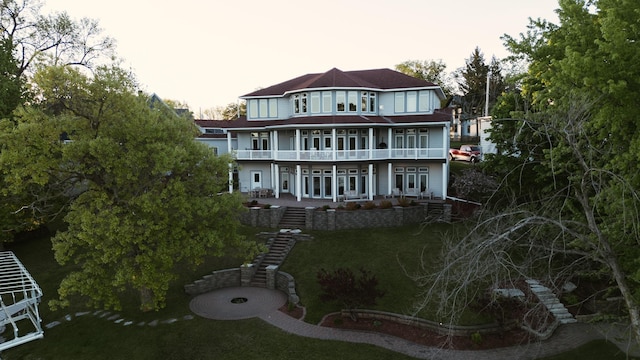 back of house with a yard, a balcony, and a patio area