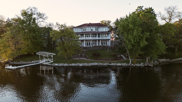 rear view of house with a balcony and a water view