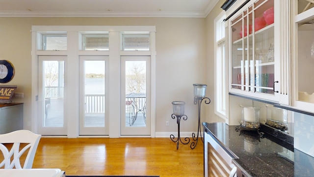 entryway with crown molding and light hardwood / wood-style flooring