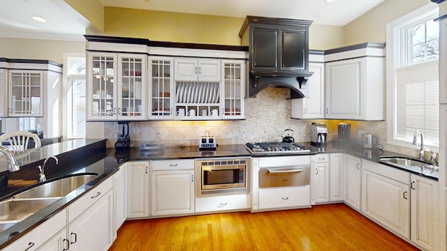 kitchen featuring sink, tasteful backsplash, stainless steel appliances, and light hardwood / wood-style floors