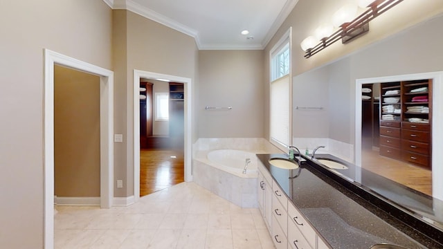 bathroom featuring tiled tub, tile patterned floors, crown molding, and double sink vanity