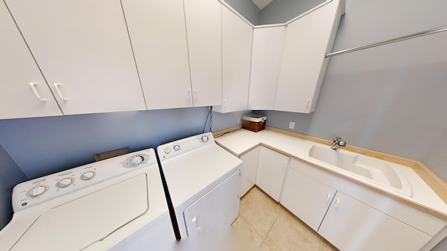 washroom featuring light tile patterned floors, washing machine and clothes dryer, and cabinets